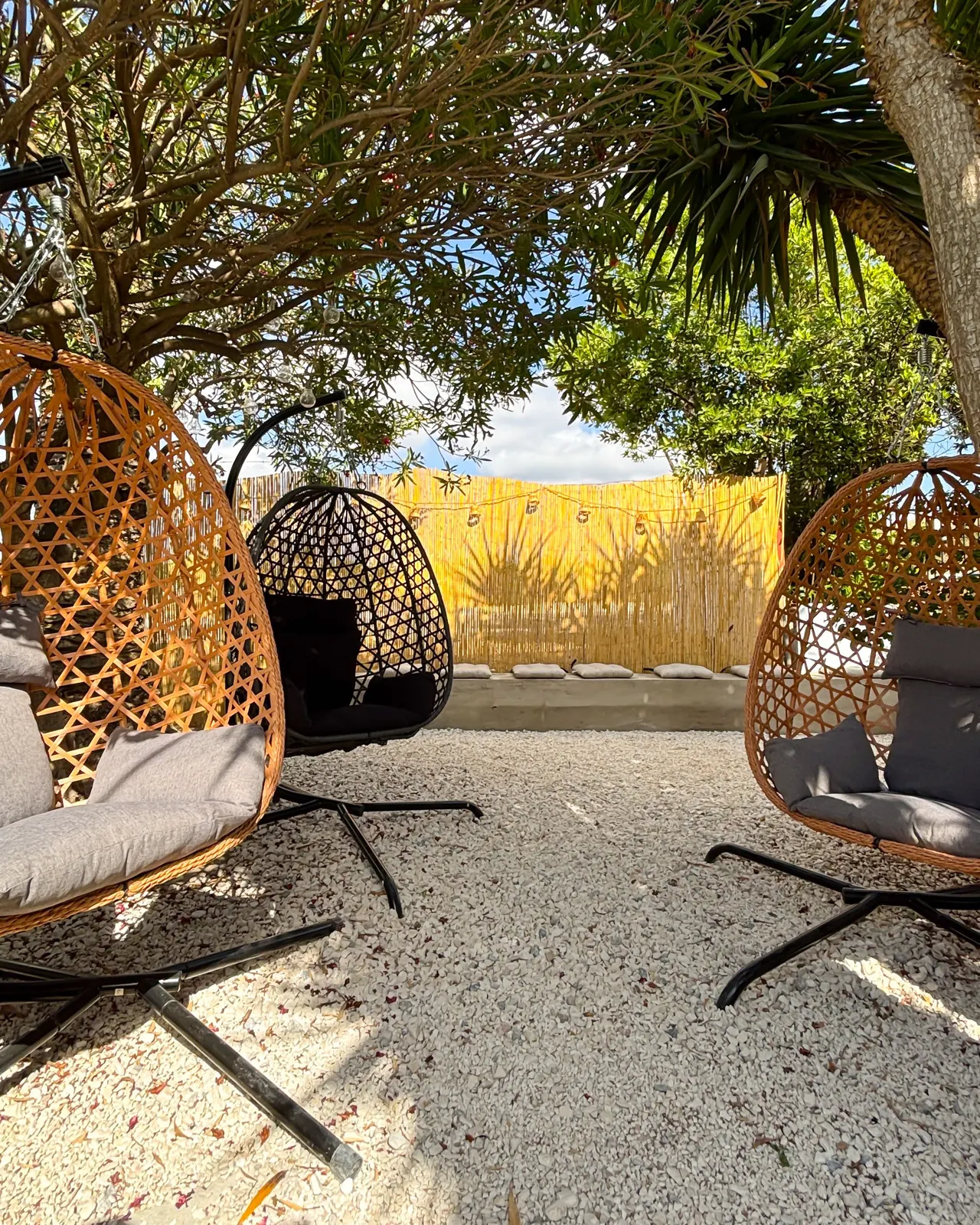 Trío de sillones colgantes en el rincón chill del jardín