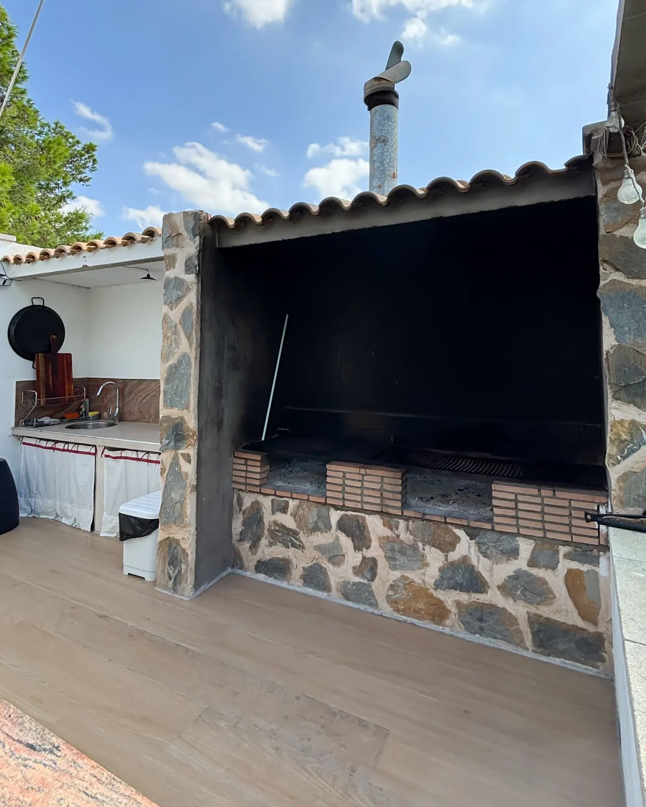 Barbacoa de obra con chimenea y parrilla de carbón